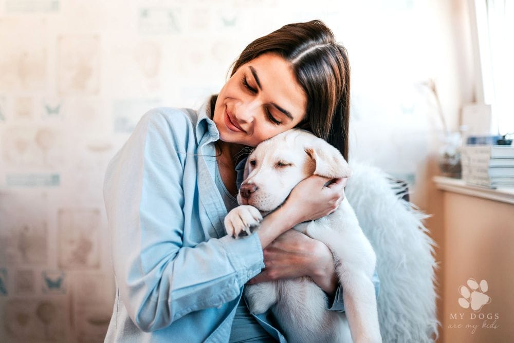 brunette girl hugging her puppy at home