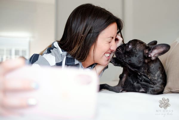 woman taking a selfie with her French bulldog